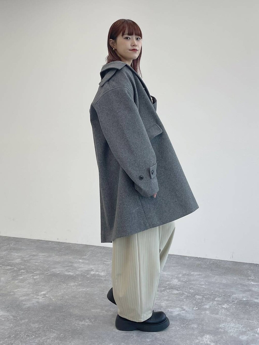 グレー系のその他アウター、グレー系のTシャツ/カットソー、ブラック系のベストを着用したレディースの秋コーディネートの2枚目の写真