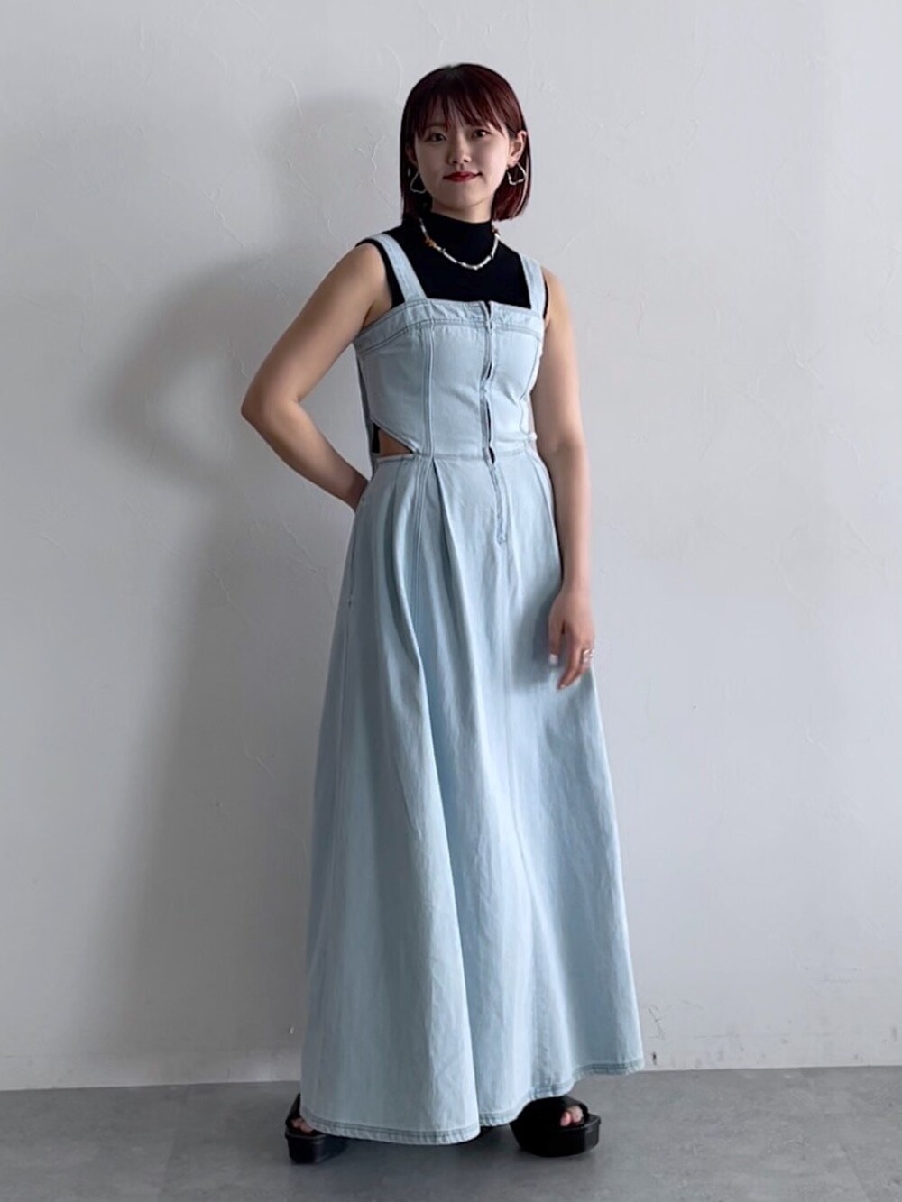 ブラック系のトップス、ブルー系のジャンパースカート、ブラック系のシューズを着用したレディースの春コーディネートの5枚目の写真