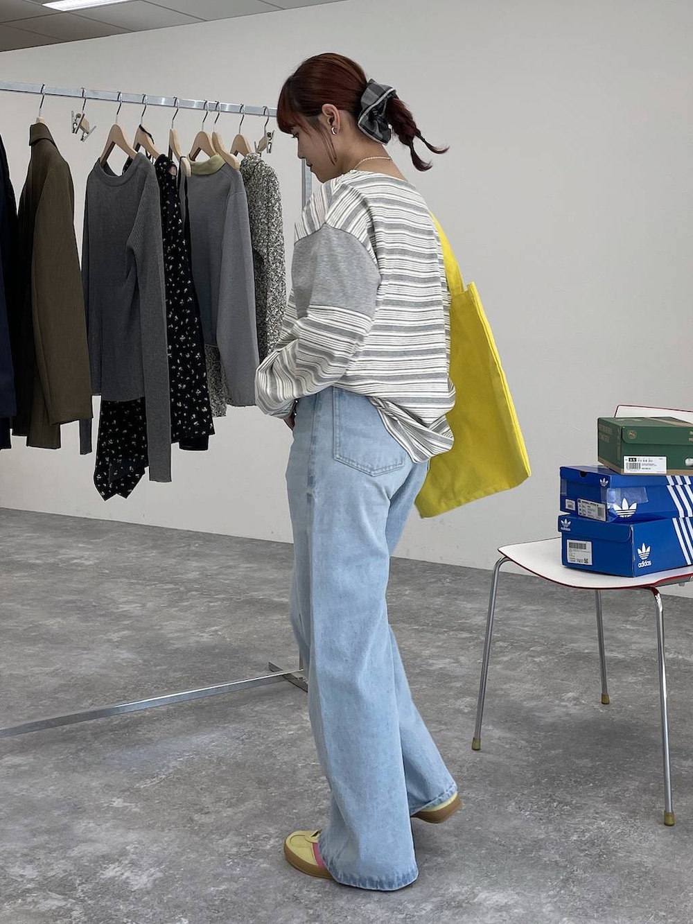 イエロー系のトートバッグ、ブルー系のデニムパンツ、グレー系のTシャツ/カットソーを着用したレディースの冬コーディネートの2枚目の写真