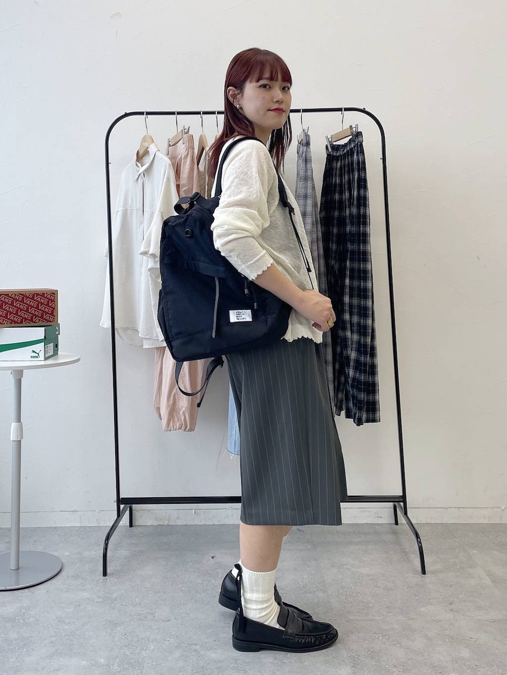 ブラック系のローファー、ブラック系のバックパック/リュック、グレー系のスラックスを着用したレディースの春コーディネートの5枚目の写真