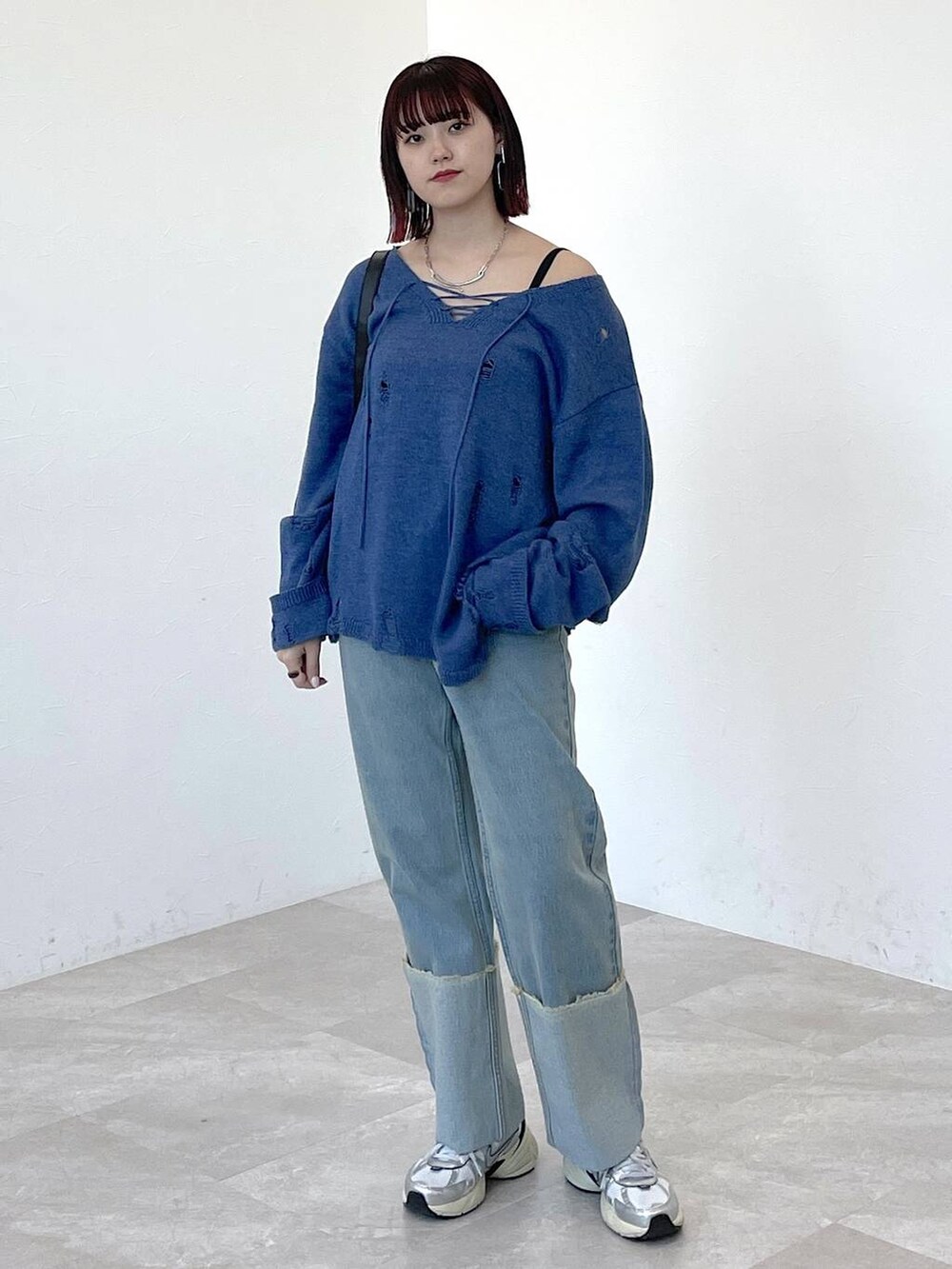 ブラック系のショルダーバッグ、ブルー系のニット/セーター、ブルー系のデニムパンツを着用したレディースの春コーディネートの9枚目の写真