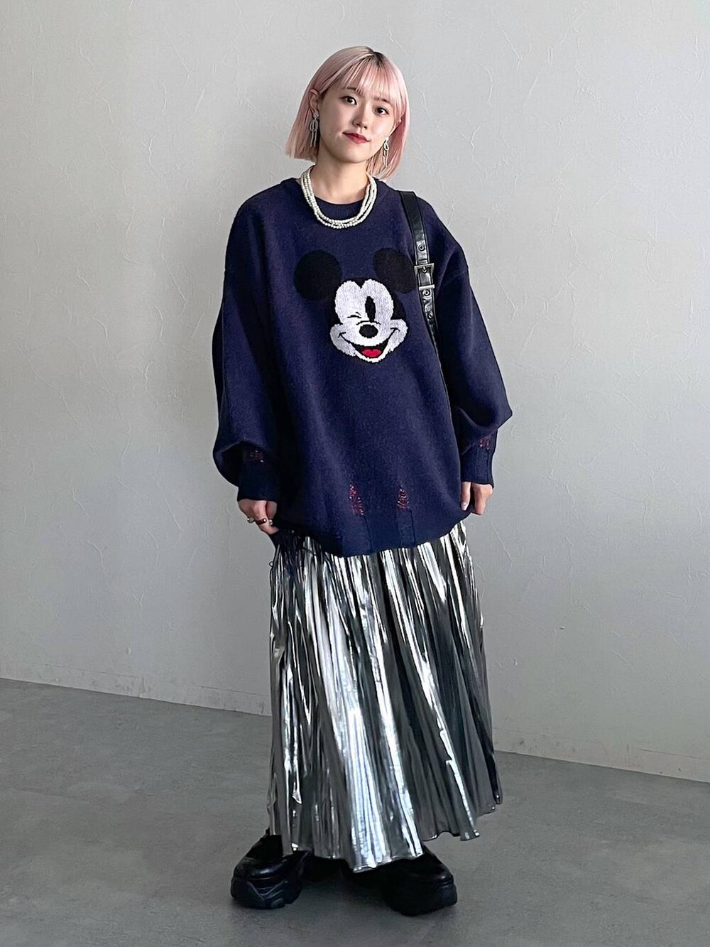 ブラック系のブーツ、ブラック系のショルダーバッグ、グレー系のスカートを着用したレディースの秋コーディネートの6枚目の写真