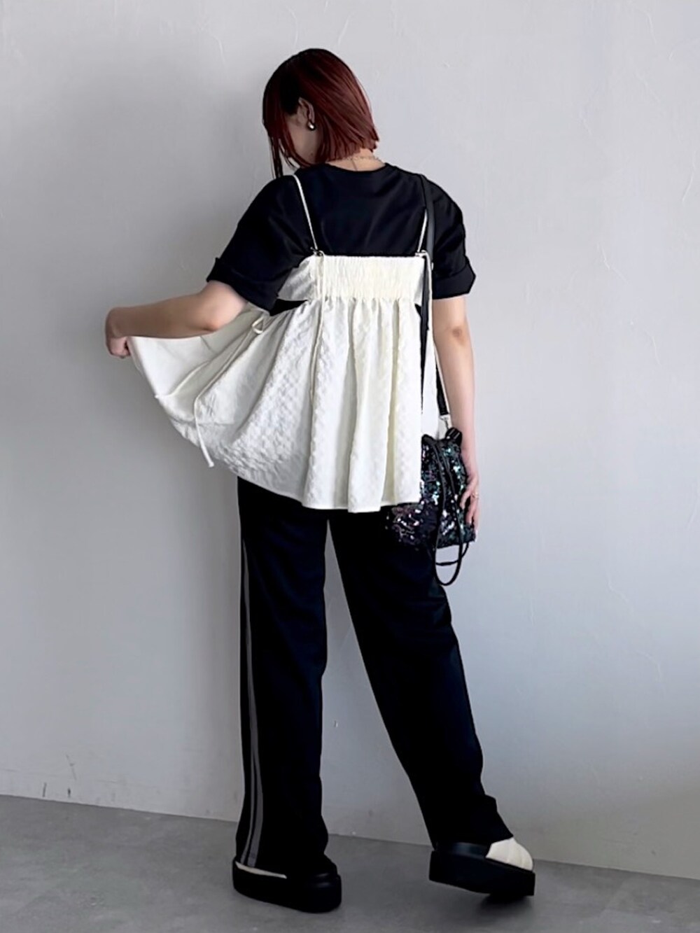 ホワイト系のキャミソール、ブラック系のスウェットパンツ、ブラック系のTシャツ/カットソーを着用したレディースの夏コーディネートの2枚目の写真