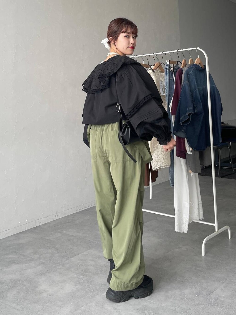 ブラック系のスニーカー、グリーン系のカーゴパンツ、ブラック系のショルダーバッグを着用したレディースの春コーディネートの2枚目の写真
