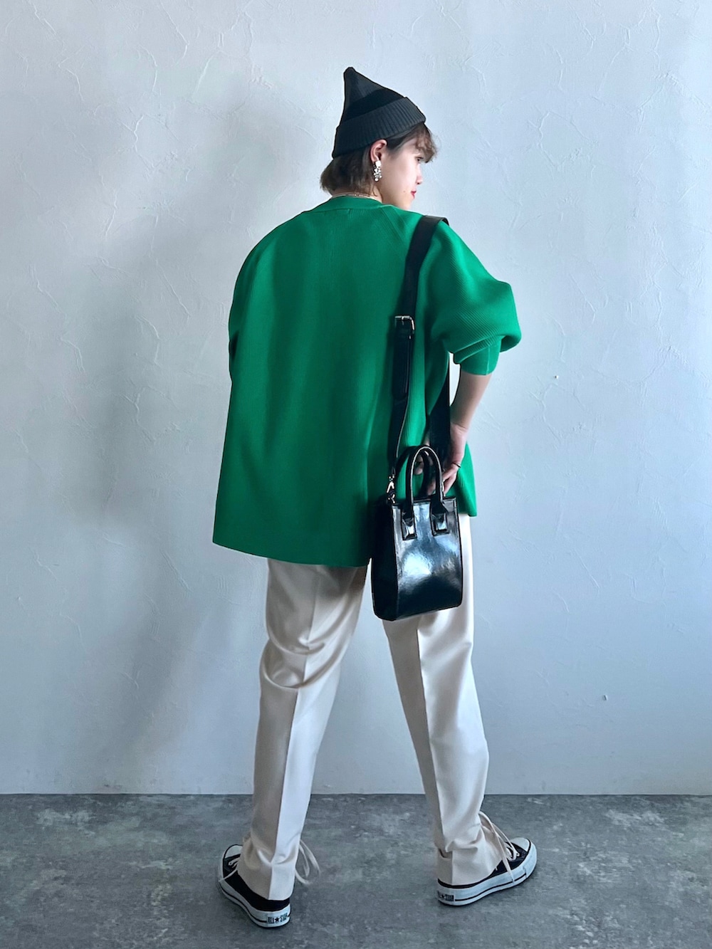 ホワイト系のその他パンツ、グリーン系のカーディガン/ボレロ、ブラック系のスニーカーを着用したレディースの冬コーディネートの2枚目の写真