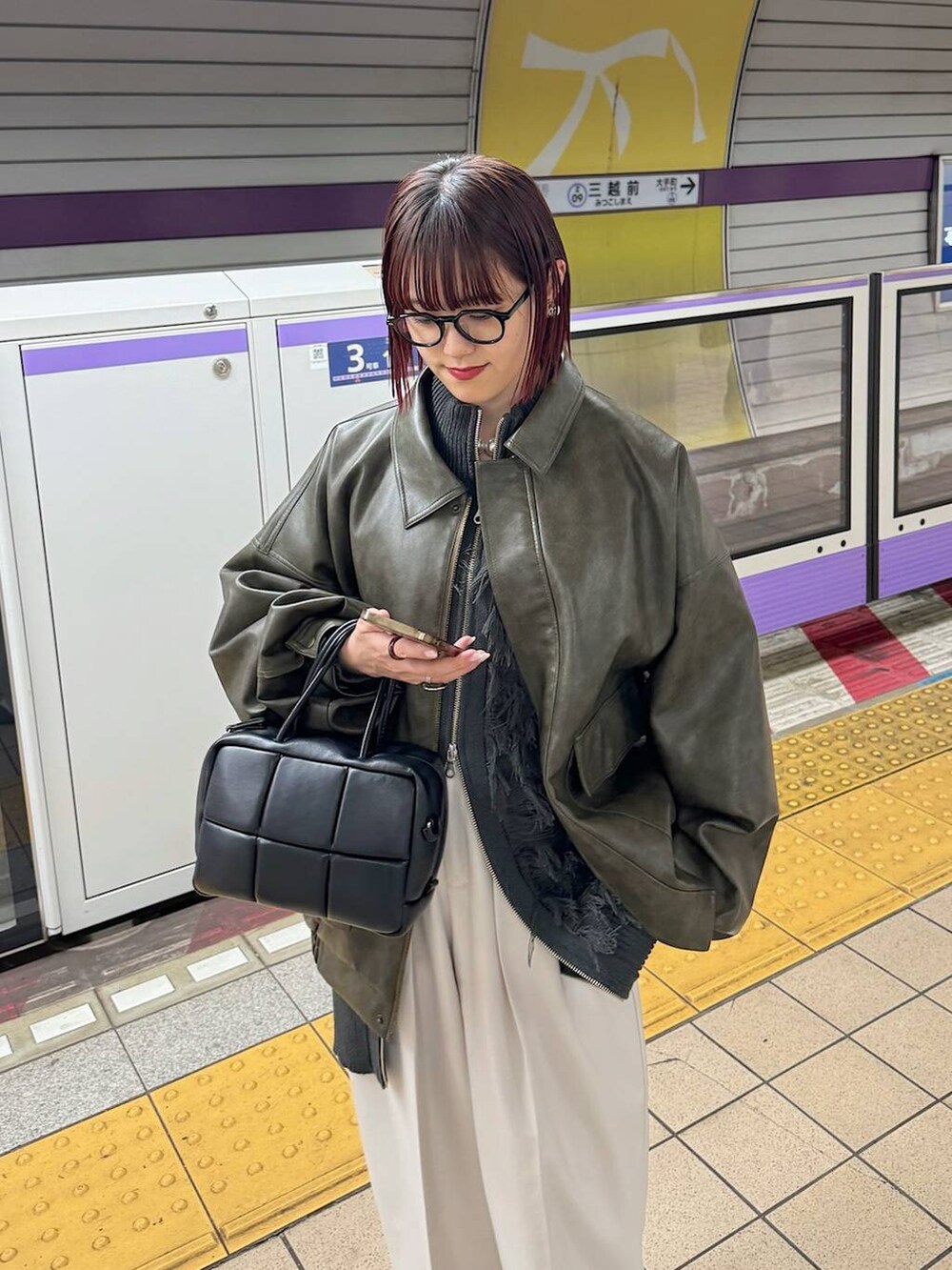 ブラウン系のブルゾン、ベージュ系のスラックス、グレー系のニット/セーターを着用したレディースの秋コーディネートの2枚目の写真