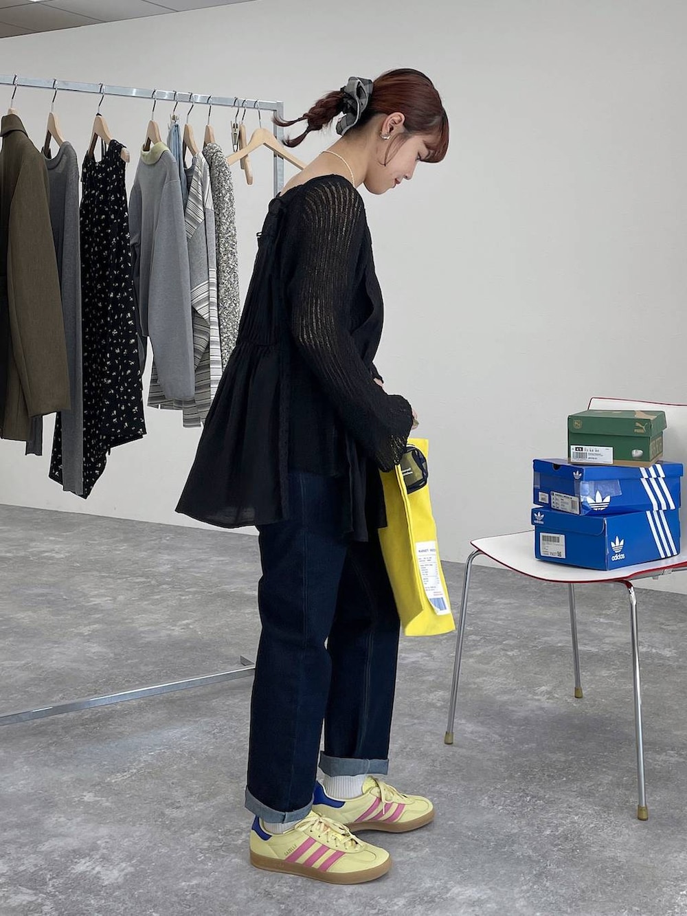 イエロー系のトートバッグ、ブルー系のデニムパンツ、ブラック系のキャミソールを着用したレディースの春コーディネートの3枚目の写真