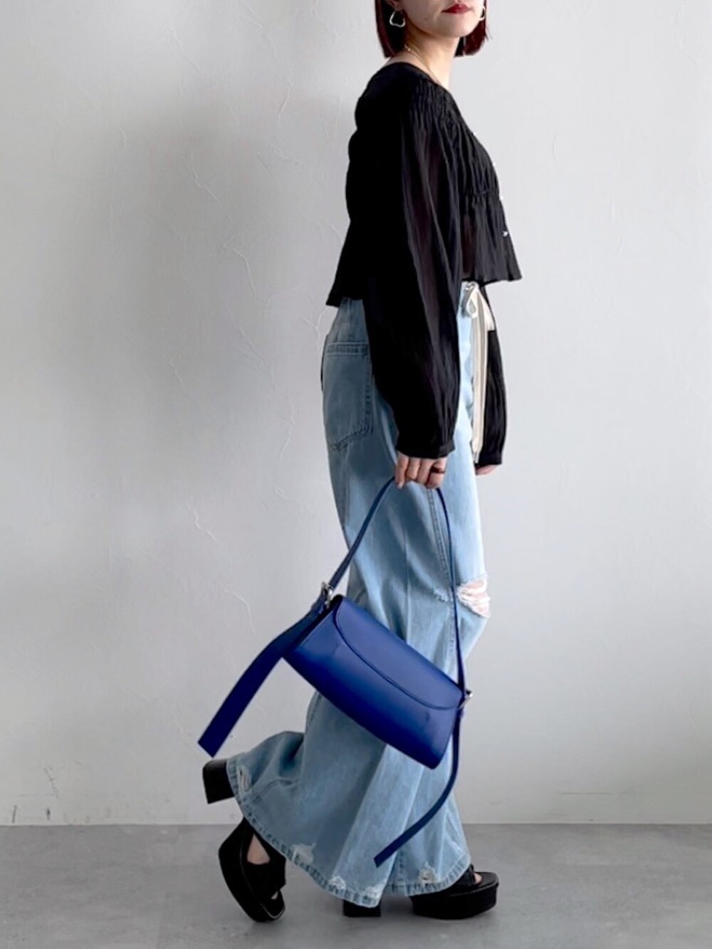 ブルー系のデニムパンツ、ブラック系のシューズ、ブラック系のシャツ/ブラウスを着用したレディースの春コーディネートの4枚目の写真