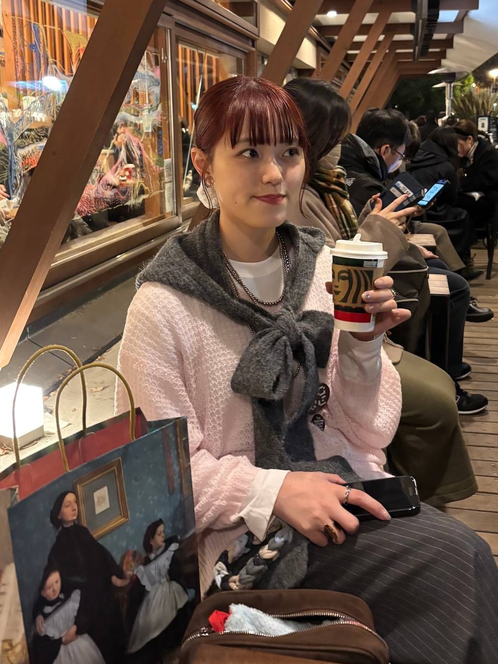 ピンク系のニット/セーター、グレー系のスラックス、グレー系のマフラーを着用したレディースの冬コーディネートの4枚目の写真