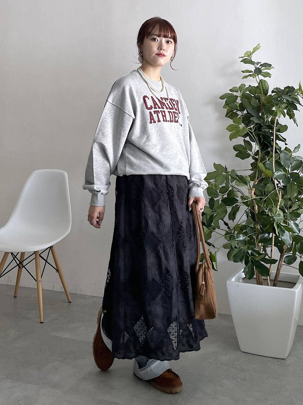 ブルー系のデニムパンツ、ブラック系のスカートを着用したレディースの秋コーディネートの5枚目の写真