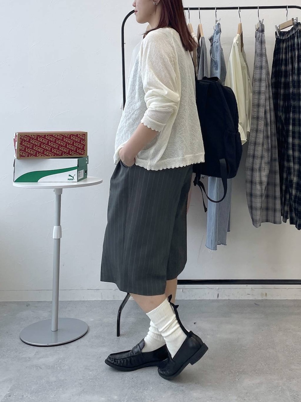 ブラック系のローファー、ブラック系のバックパック/リュック、グレー系のスラックスを着用したレディースの春コーディネートの3枚目の写真