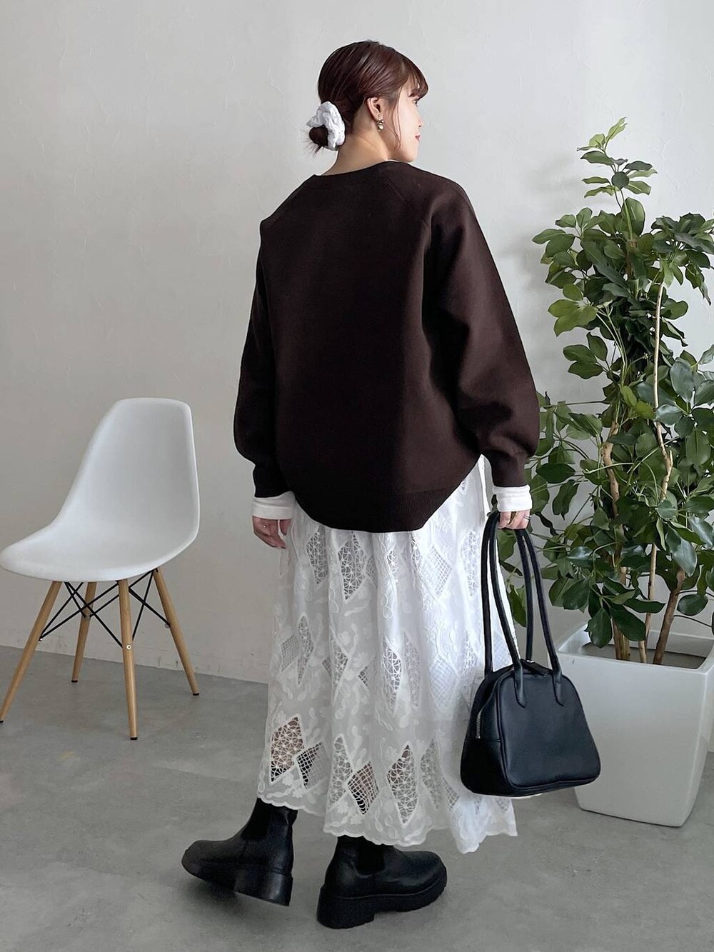 ホワイト系のTシャツ/カットソー、グレー系のニット/セーターを着用したレディースの秋コーディネートの2枚目の写真