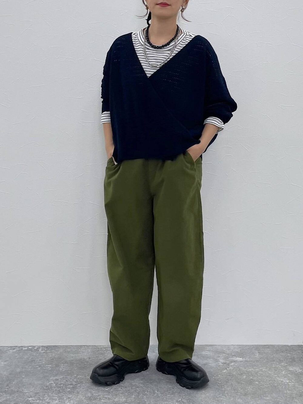 グリーン系のその他パンツ、ブラック系のブーツ、その他のTシャツ/カットソーを着用したレディースの秋コーディネートの6枚目の写真