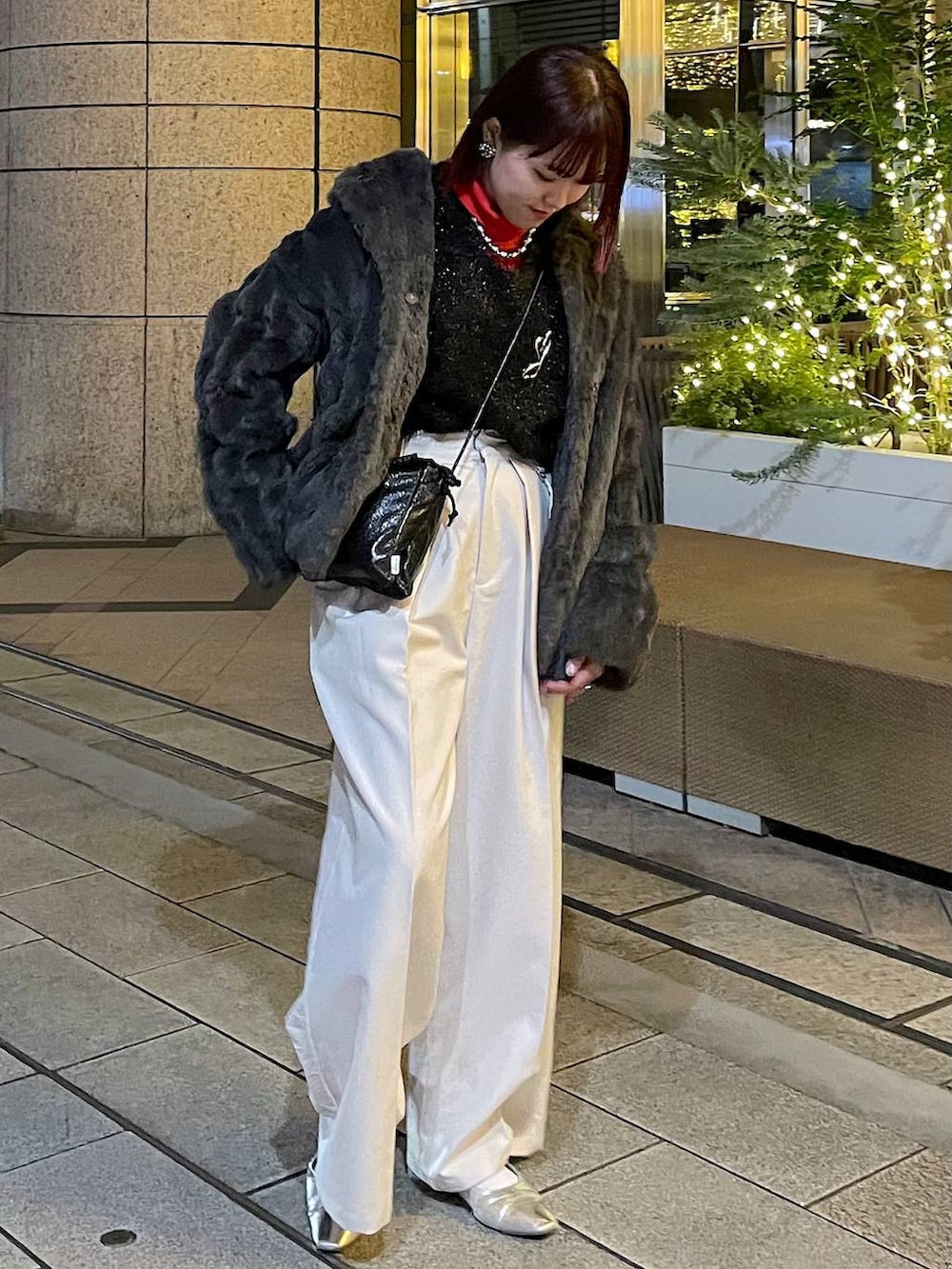 グレー系のブルゾン、ブラック系のニット/セーター、ベージュ系のスラックスを着用したレディースの冬コーディネートの5枚目の写真