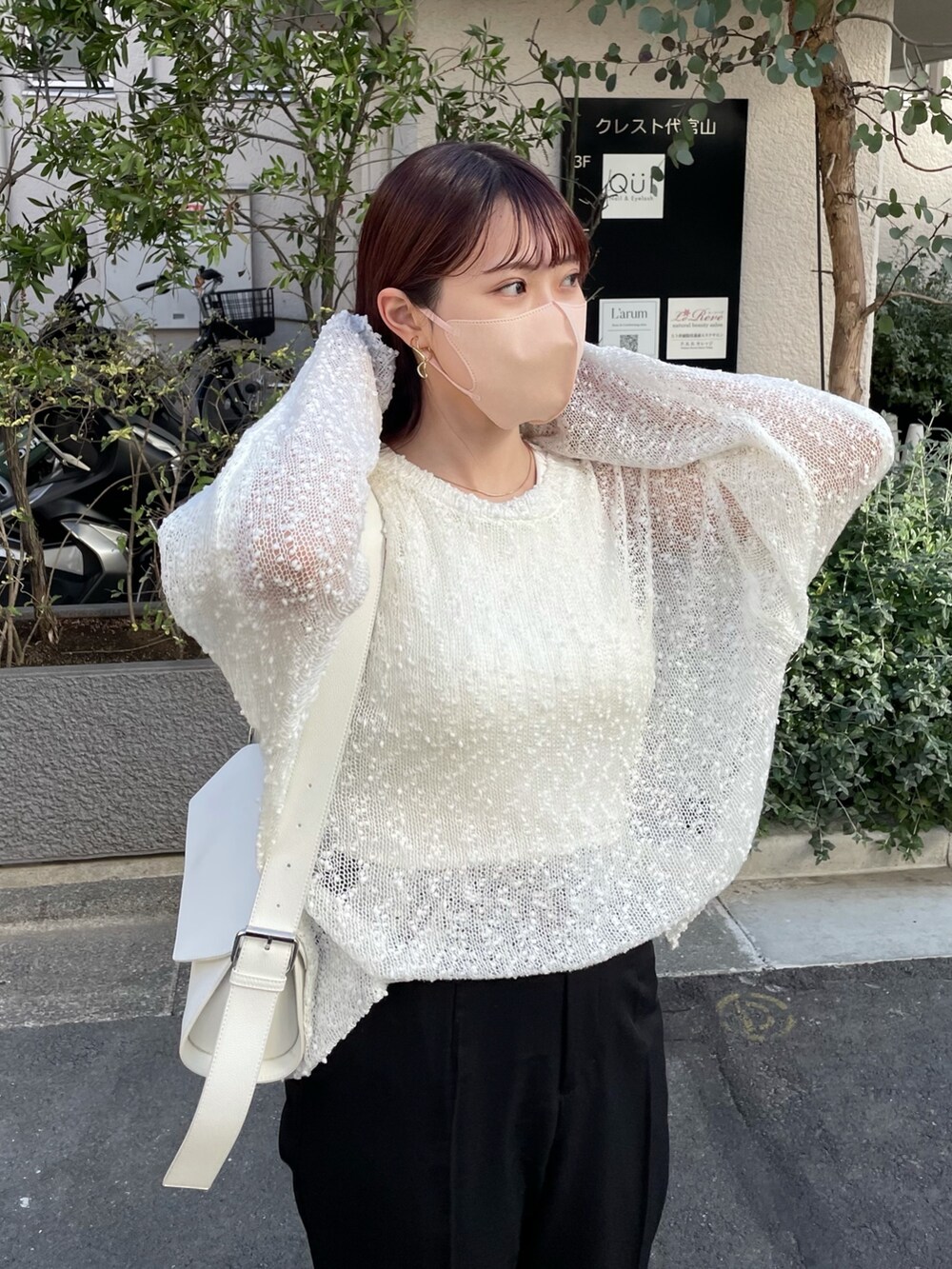 ホワイト系のタンクトップ、ブラック系のスラックス、ホワイト系のバッグを着用したレディースの春コーディネートの3枚目の写真