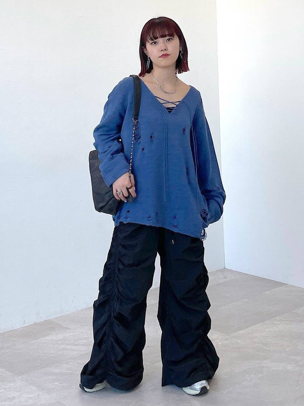 ブラック系のショルダーバッグ、ブルー系のニット/セーター、ブラック系のその他パンツを着用したレディースの冬コーディネートの3枚目の写真