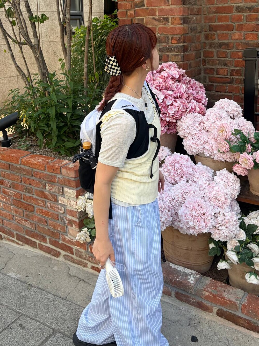 ブラック系のスニーカー、ホワイト系のタンクトップ、ブルー系のその他パンツを着用したレディースの夏コーディネートの2枚目の写真