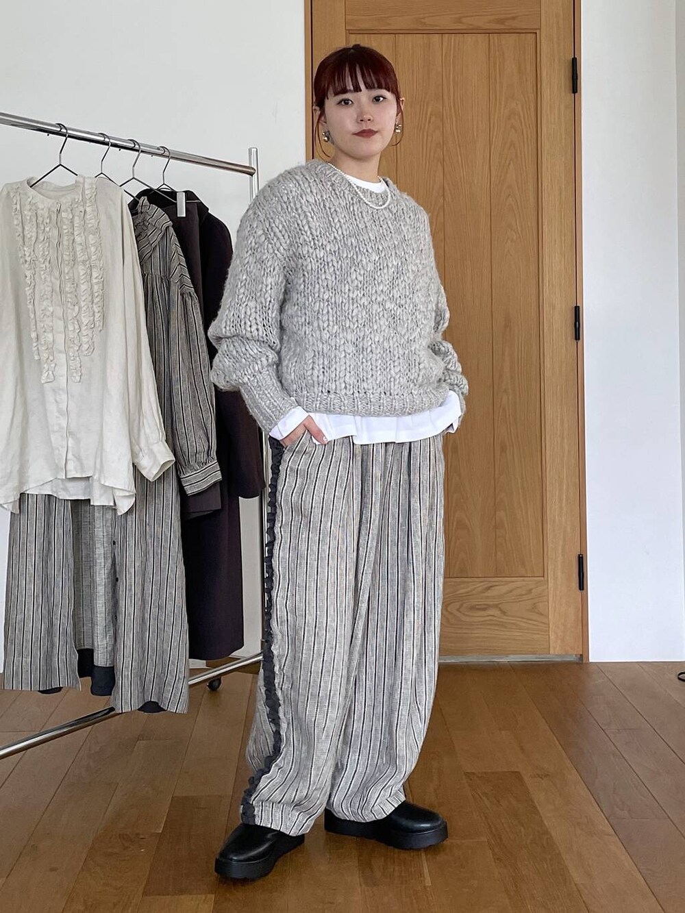 ブラック系のブーツ、その他のTシャツ/カットソー、グレー系のニット/セーターを着用したレディースの秋コーディネートの2枚目の写真