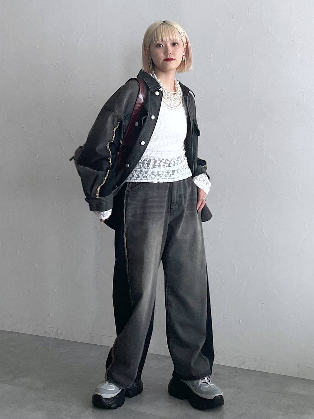 ホワイト系のTシャツ/カットソー、ブラック系のデニムパンツ、ブラック系のブルゾンを着用したレディースの夏コーディネートの6枚目の写真