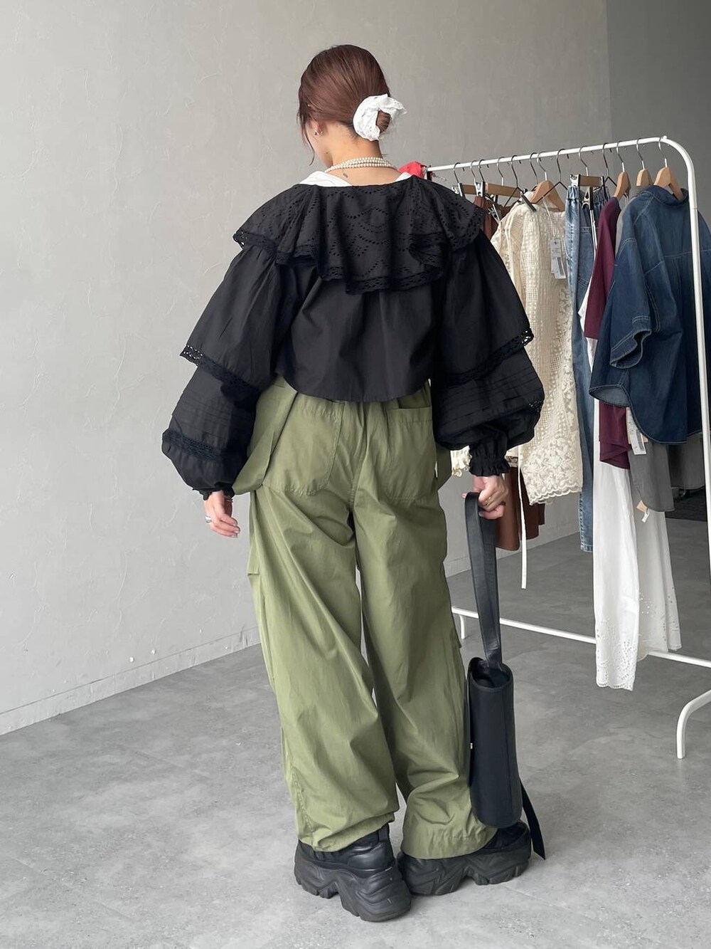 ブラック系のスニーカー、グリーン系のカーゴパンツ、ブラック系のショルダーバッグを着用したレディースの春コーディネートの4枚目の写真