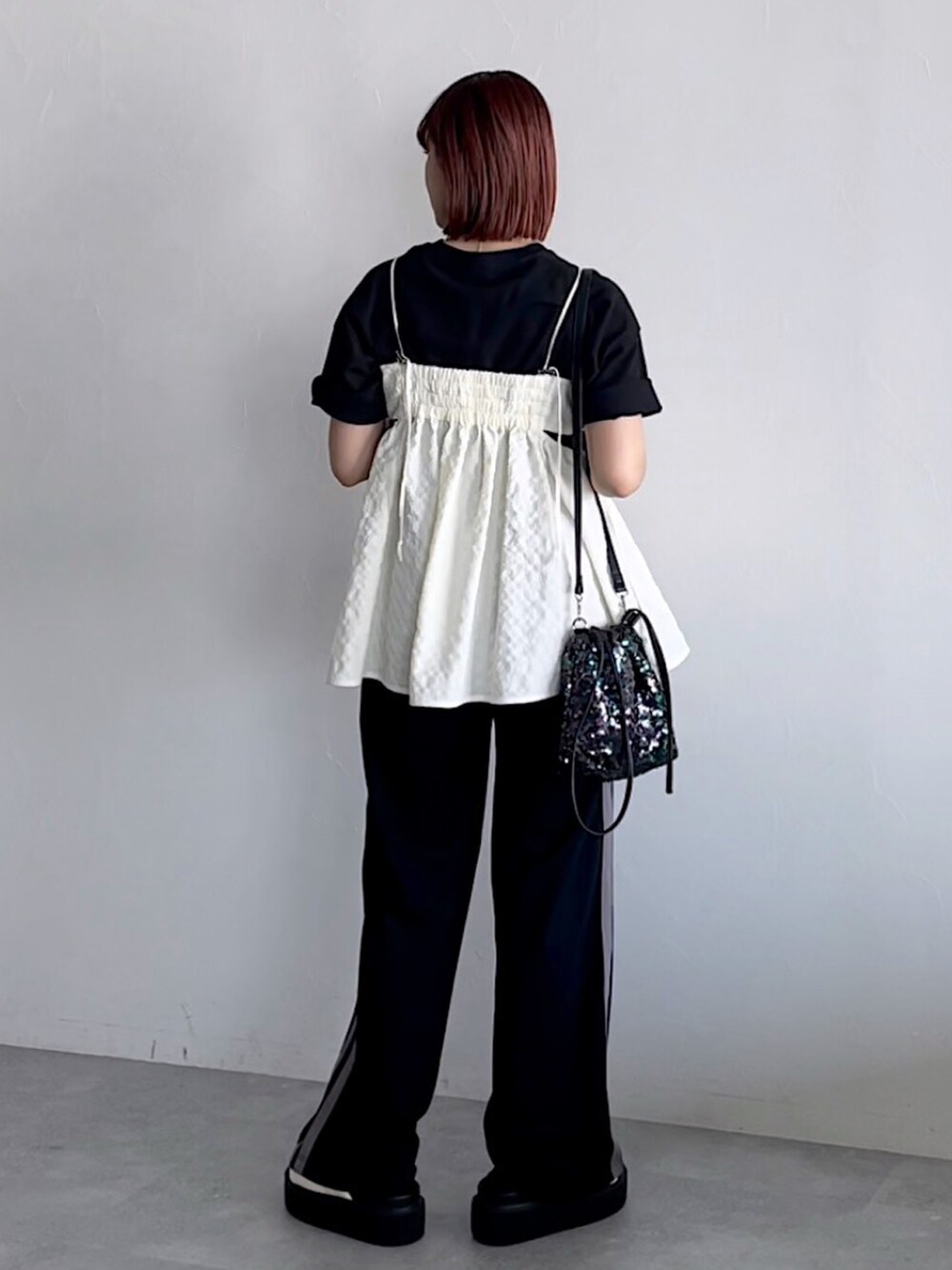 ホワイト系のキャミソール、ブラック系のスウェットパンツ、ブラック系のTシャツ/カットソーを着用したレディースの夏コーディネートの5枚目の写真