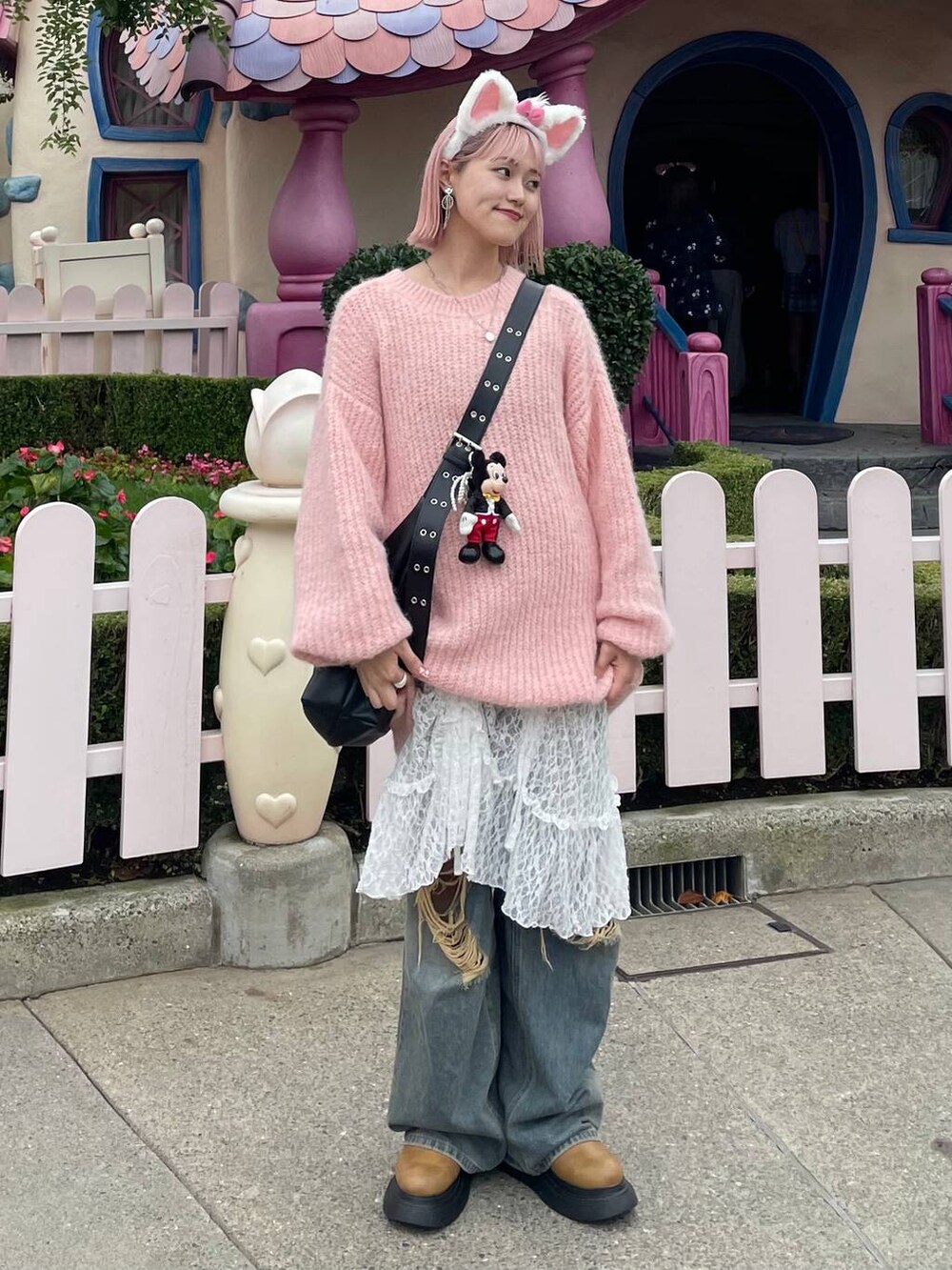 ブルー系のデニムパンツ、ブラック系のボディバッグ/ウエストポーチ、イエロー系のブーツを着用したレディースの秋コーディネートの5枚目の写真