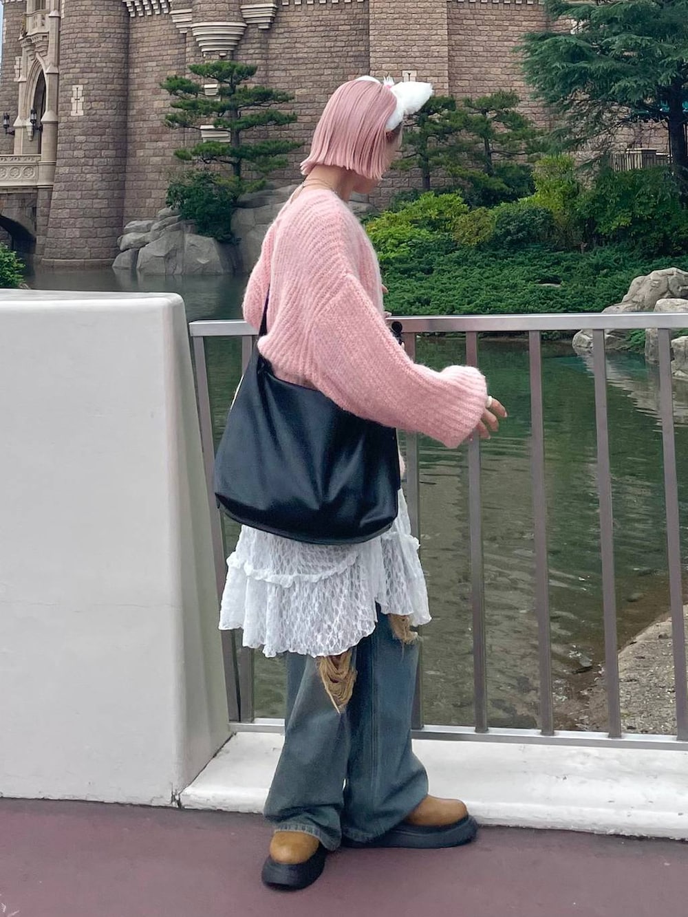 ブルー系のデニムパンツ、ブラック系のボディバッグ/ウエストポーチ、イエロー系のブーツを着用したレディースの秋コーディネートの2枚目の写真