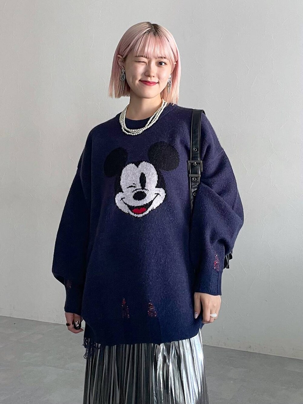 ブラック系のブーツ、ブラック系のショルダーバッグ、グレー系のスカートを着用したレディースの秋コーディネートの7枚目の写真