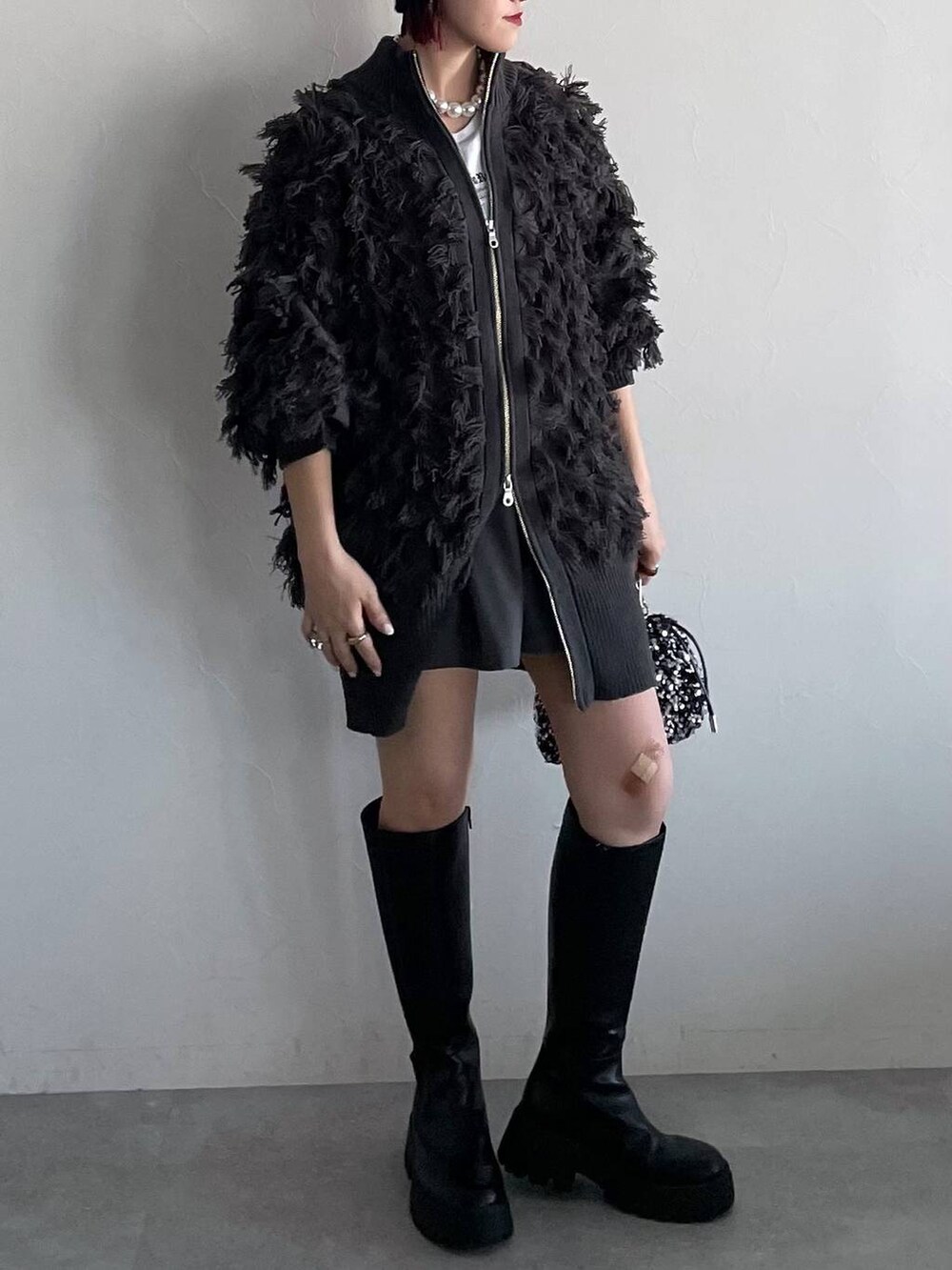 ブラック系のブーツ、グレー系のその他パンツ、シルバー系のショルダーバッグを着用したレディースの秋コーディネートの4枚目の写真