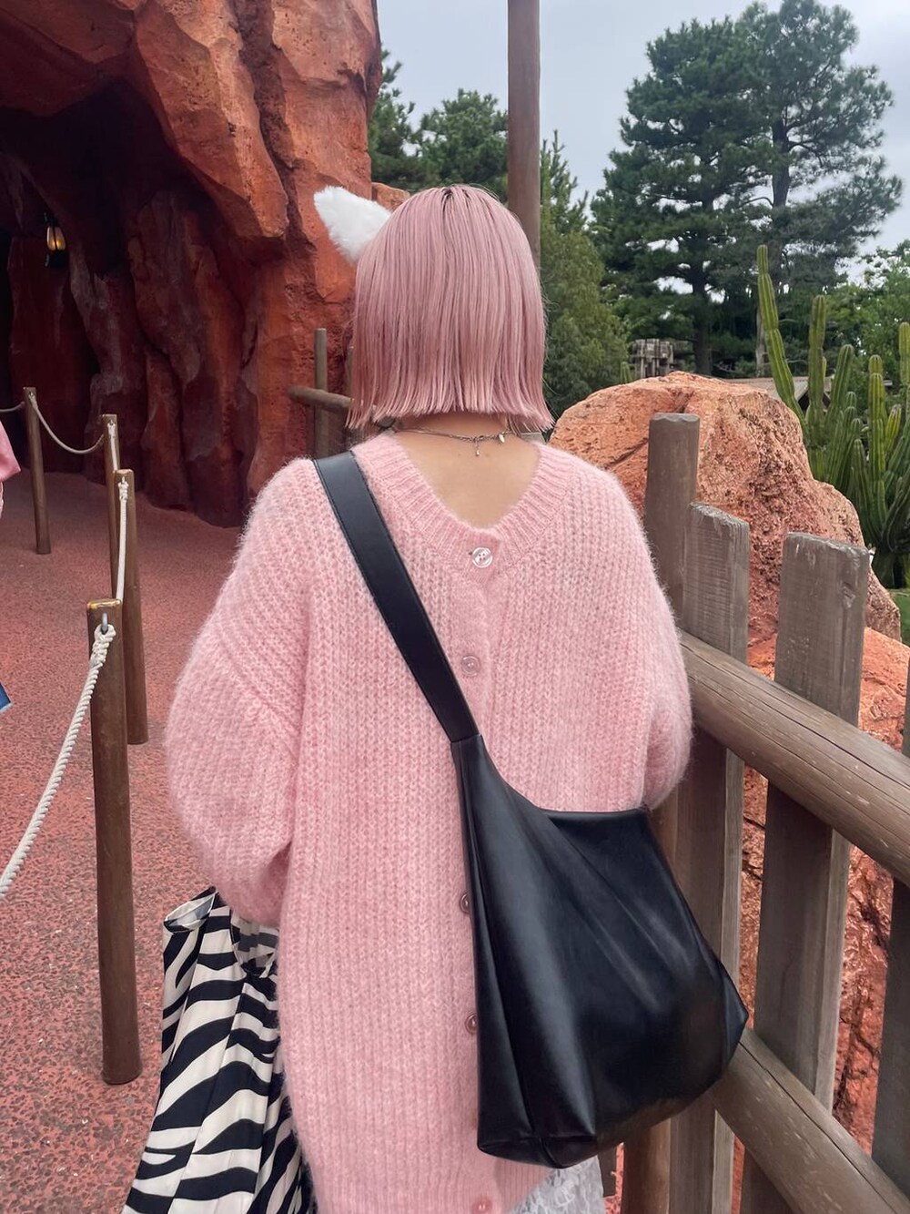 ブルー系のデニムパンツ、ブラック系のボディバッグ/ウエストポーチ、イエロー系のブーツを着用したレディースの秋コーディネートの3枚目の写真