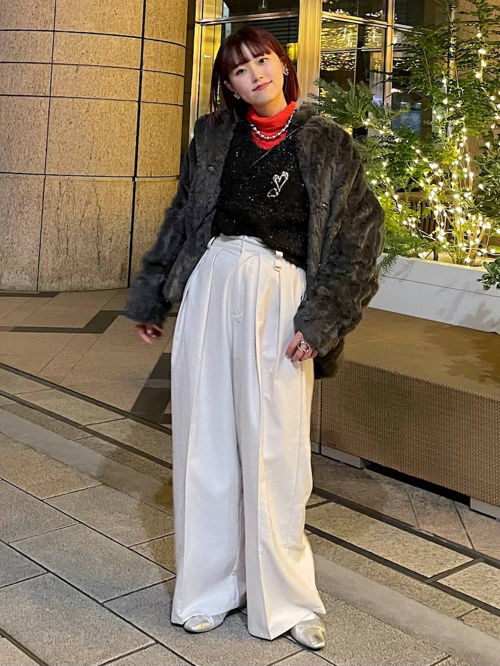 グレー系のブルゾン、ブラック系のニット/セーター、ベージュ系のスラックスを着用したレディースの冬コーディネートの7枚目の写真