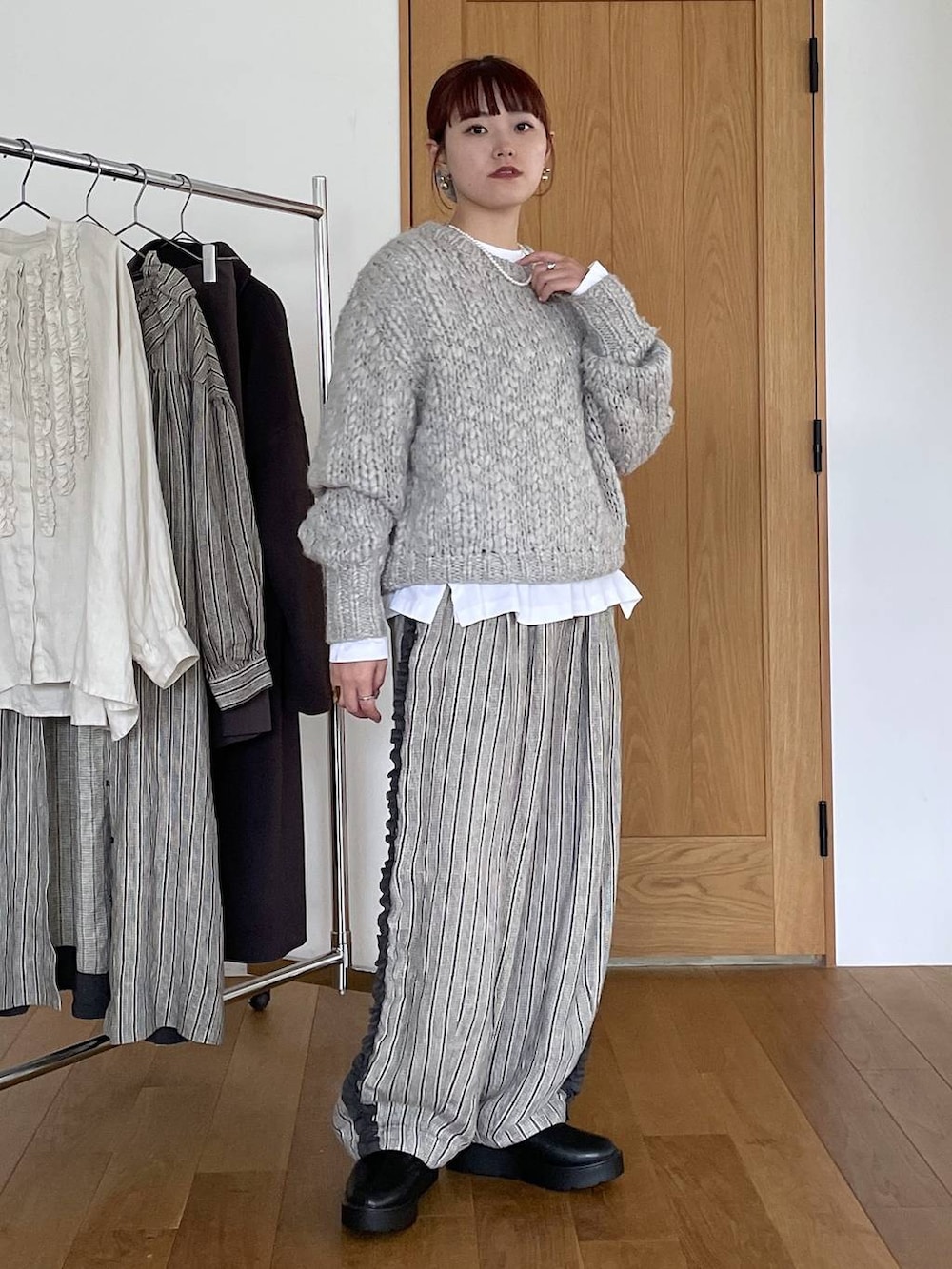 ブラック系のブーツ、その他のTシャツ/カットソー、グレー系のニット/セーターを着用したレディースの秋コーディネートの5枚目の写真