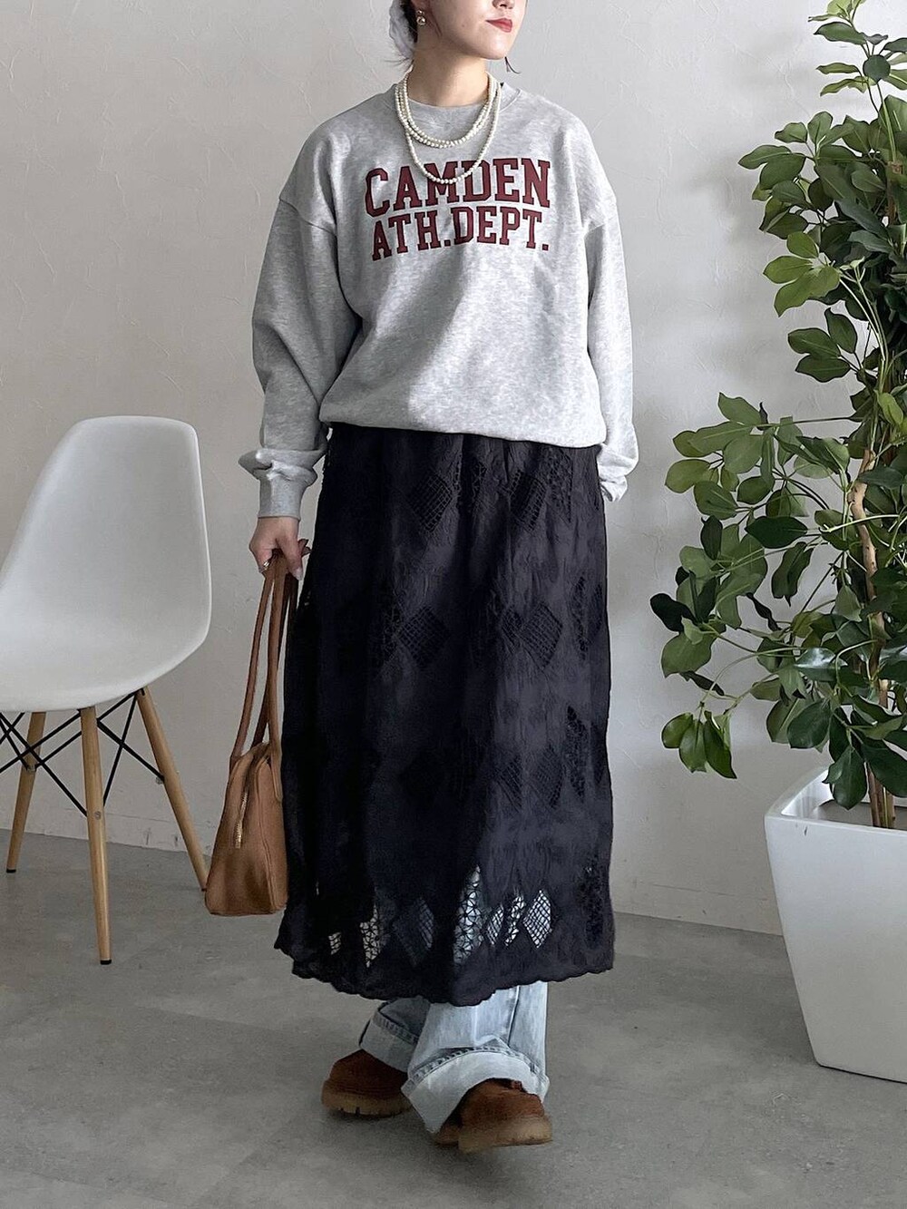 ブルー系のデニムパンツ、ブラック系のスカートを着用したレディースの秋コーディネートの3枚目の写真