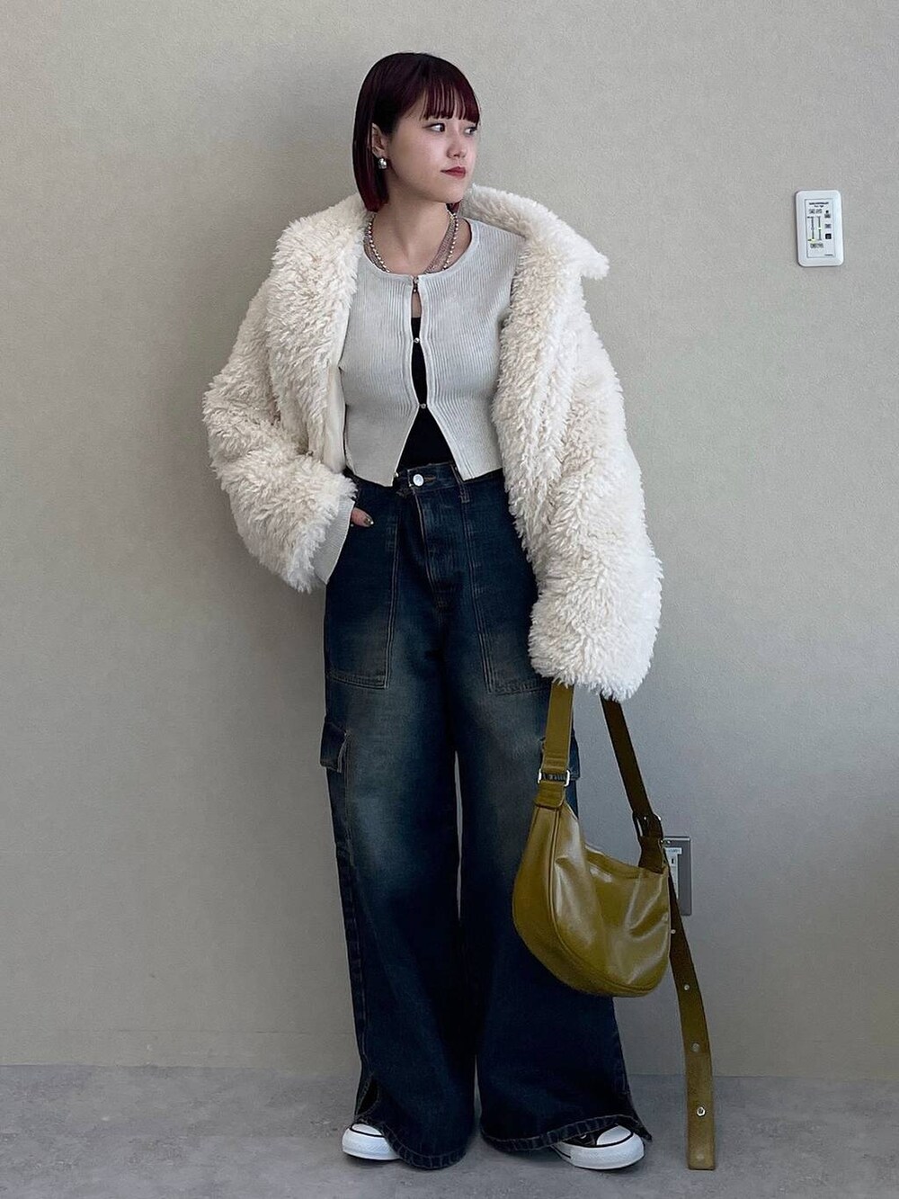 イエロー系のショルダーバッグ、ブルー系のデニムパンツ、ホワイト系のその他アウターを着用したレディースの冬コーディネートの7枚目の写真