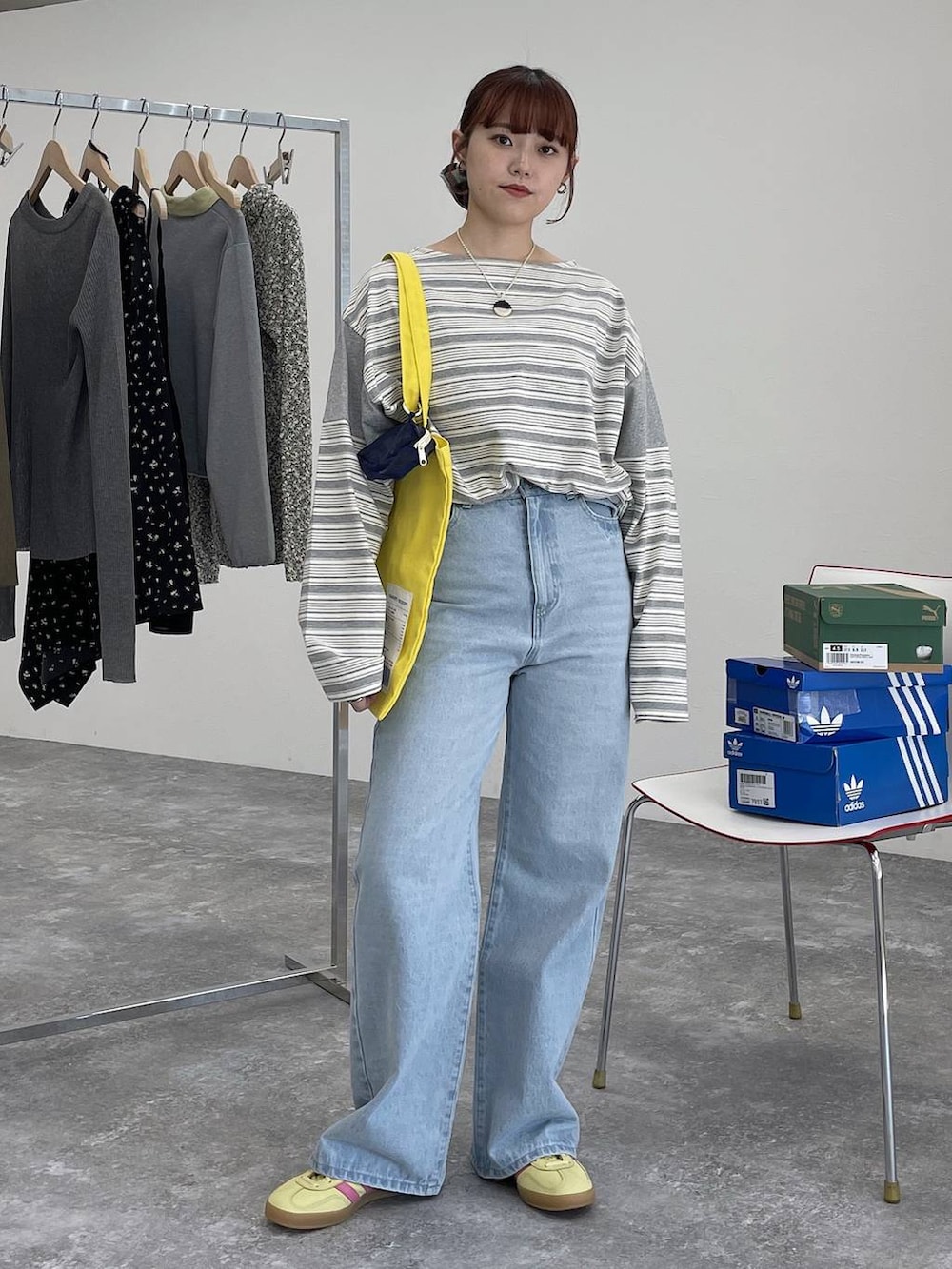 イエロー系のトートバッグ、ブルー系のデニムパンツ、グレー系のTシャツ/カットソーを着用したレディースの冬コーディネートの6枚目の写真