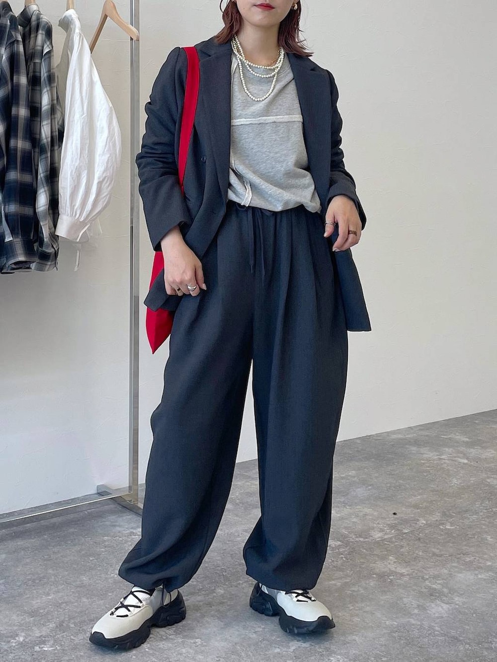 グレー系のその他パンツ、グレー系のテーラードジャケット、ホワイト系のスニーカーを着用したレディースの秋コーディネートの2枚目の写真