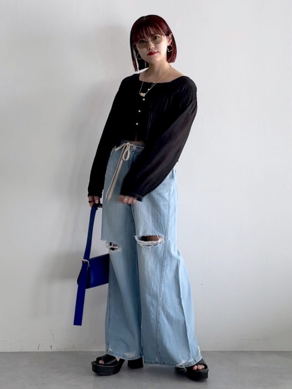 ブルー系のデニムパンツ、ブラック系のシューズ、ブラック系のシャツ/ブラウスを着用したレディースの春コーディネートの3枚目の写真