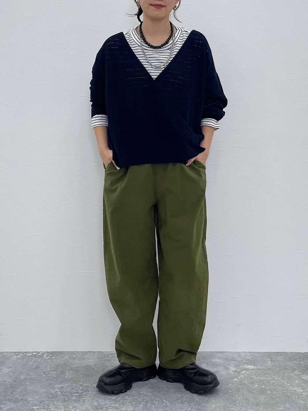 グリーン系のその他パンツ、ブラック系のブーツ、その他のTシャツ/カットソーを着用したレディースの秋コーディネートの2枚目の写真