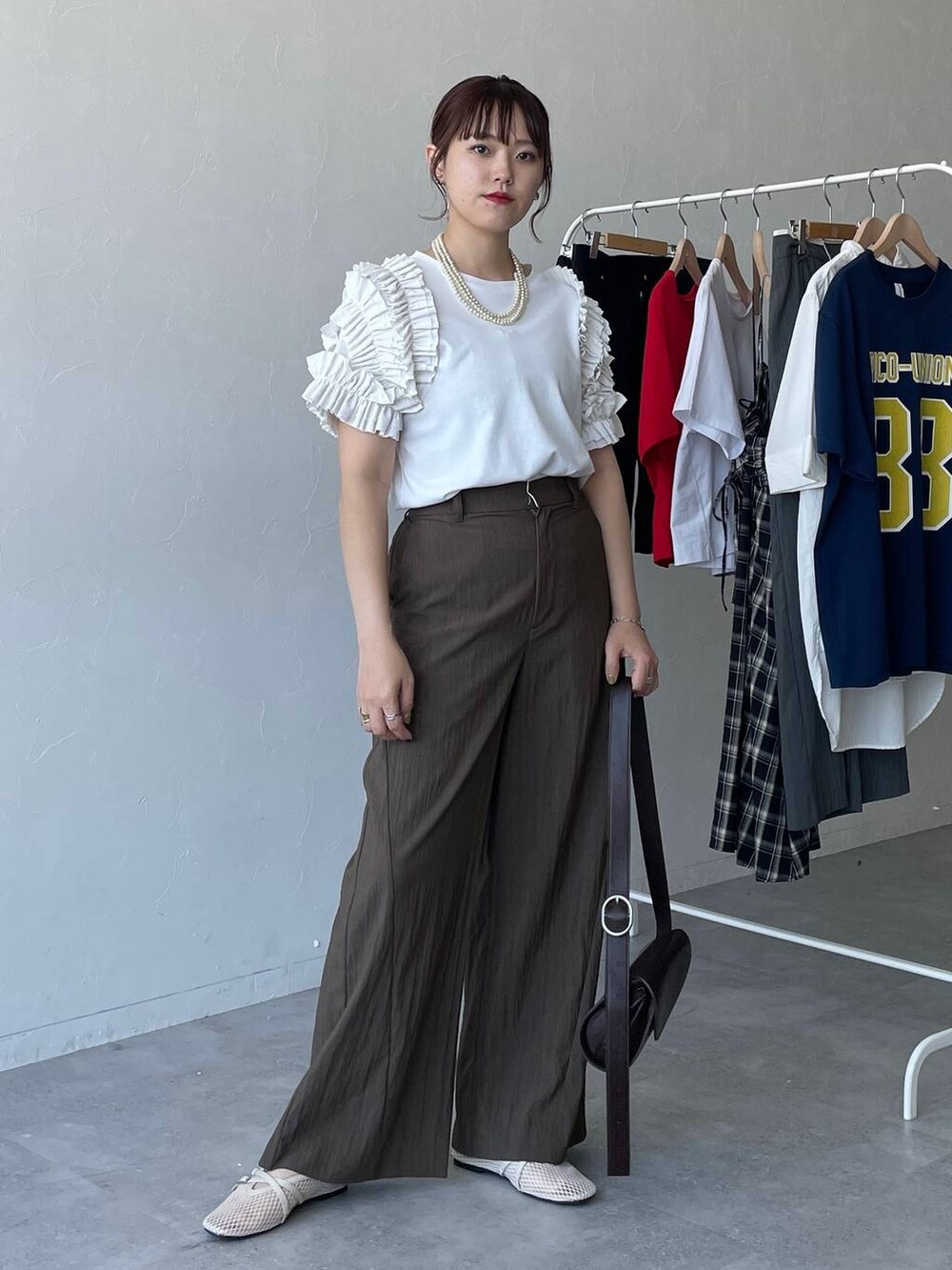 ブラウン系のショルダーバッグ、ホワイト系のTシャツ/カットソー、ブラウン系のその他パンツを着用したレディースの夏コーディネートの5枚目の写真