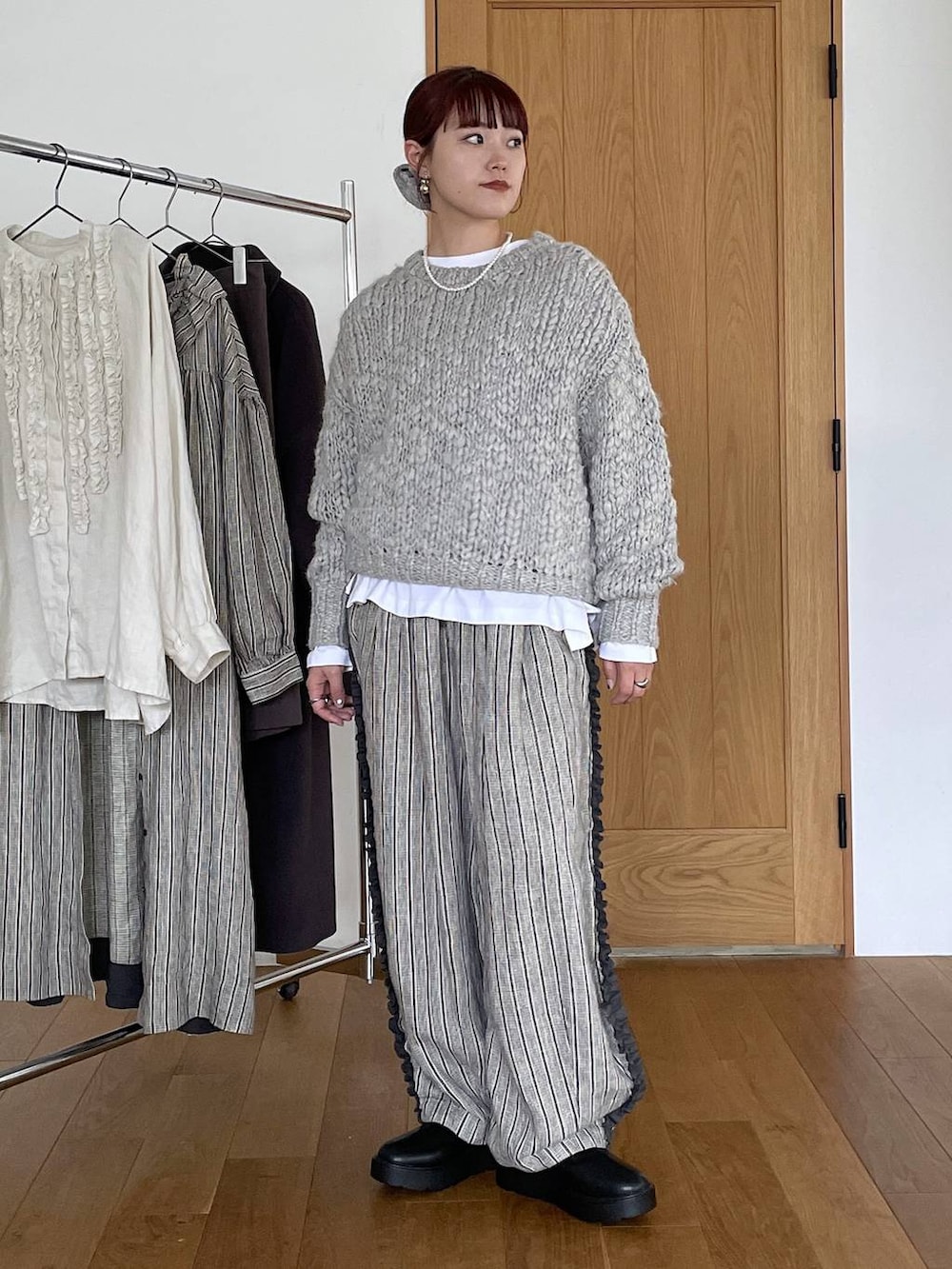 ブラック系のブーツ、その他のTシャツ/カットソー、グレー系のニット/セーターを着用したレディースの秋コーディネートの6枚目の写真