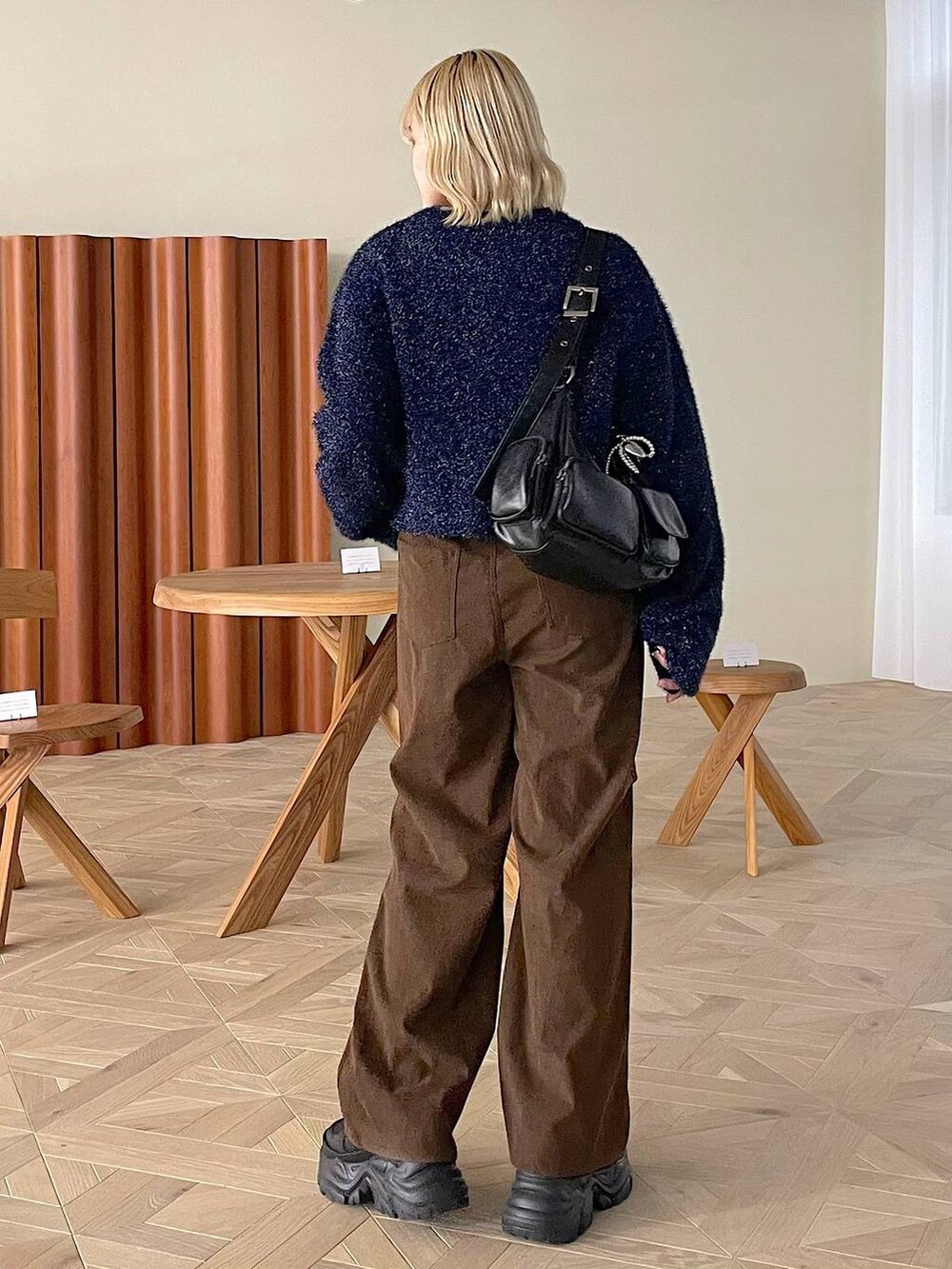 ブラック系のスニーカー、ホワイト系のショルダーバッグ、ブラウン系のその他パンツを着用したレディースの冬コーディネートの3枚目の写真