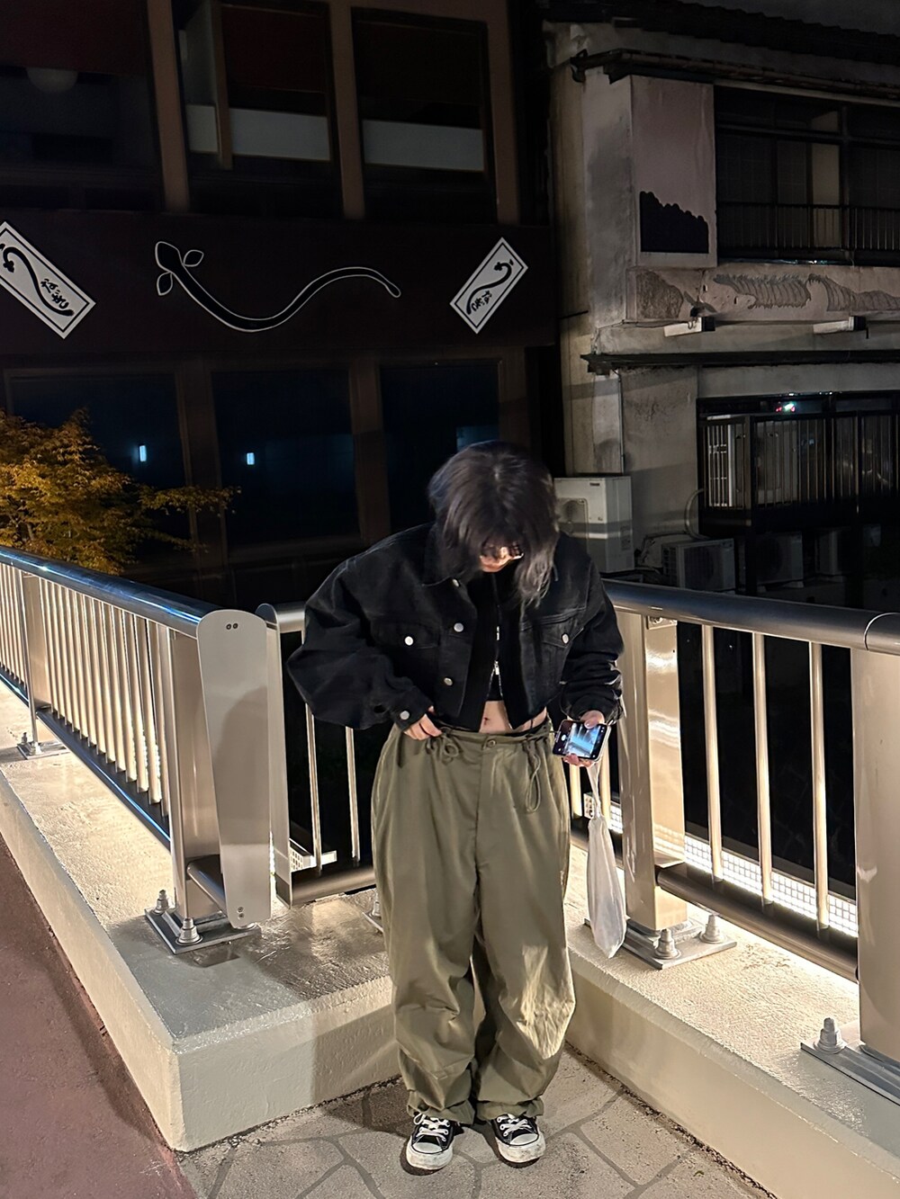 ブラック系のニット/セーター、グリーン系のカーゴパンツ、ブラック系のデニムジャケットを着用したレディースの夏コーディネートの3枚目の写真
