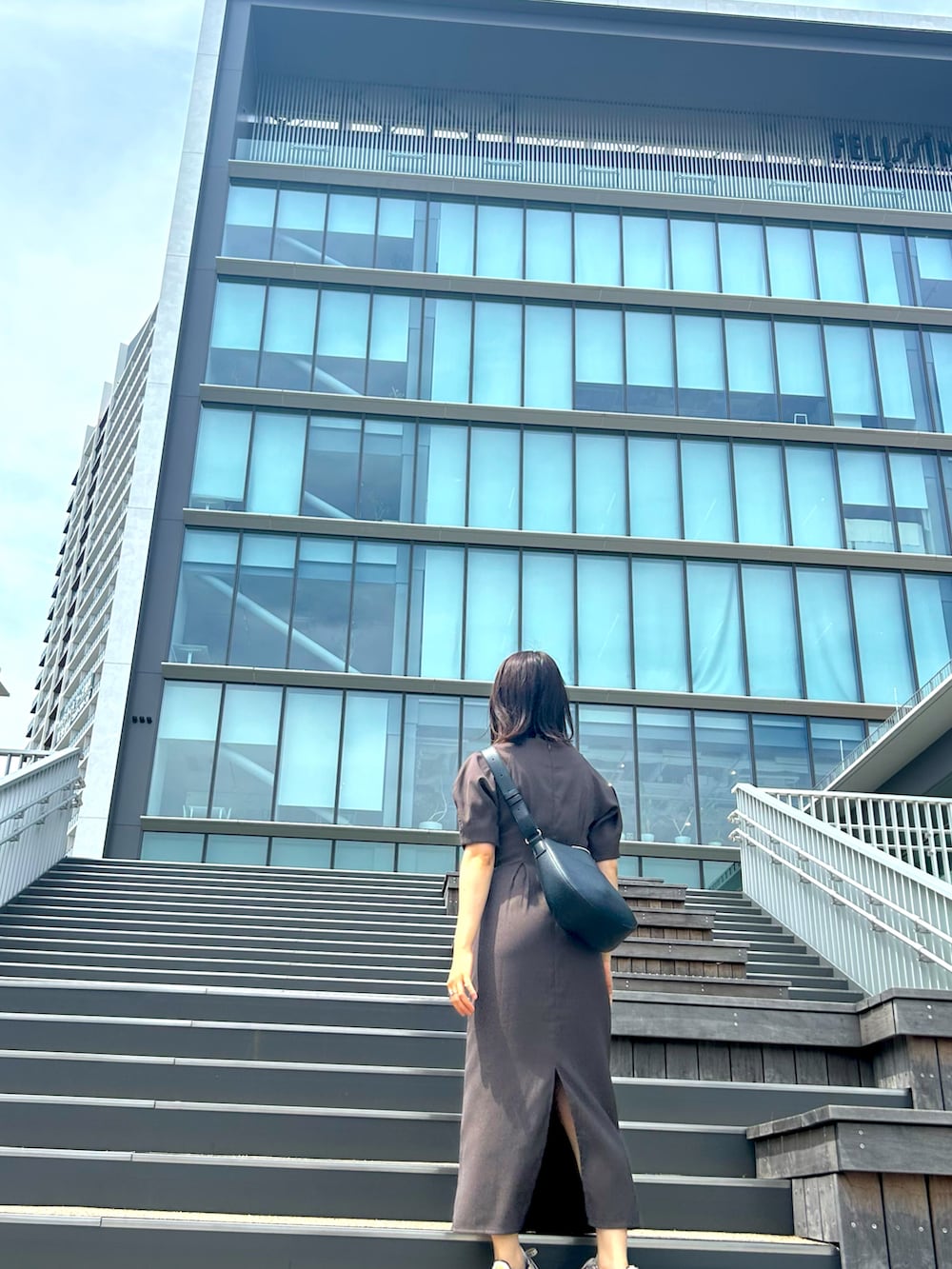 グレー系のワンピース、ピンク系のスニーカーを着用したレディースの夏コーディネートの4枚目の写真