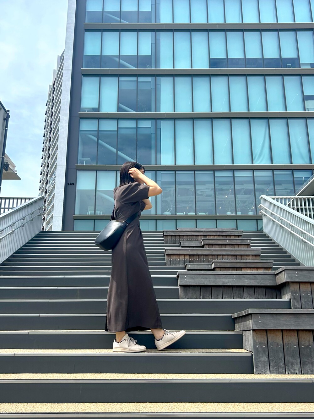 グレー系のワンピース、ピンク系のスニーカーを着用したレディースの夏コーディネートの2枚目の写真