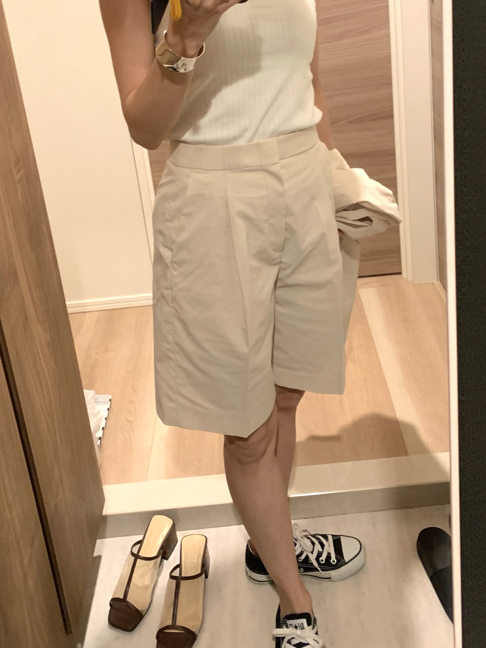 ベージュ系のテーラードジャケット、ベージュ系のローファー、グリーン系のイヤリングを着用したレディースの春コーディネートの3枚目の写真