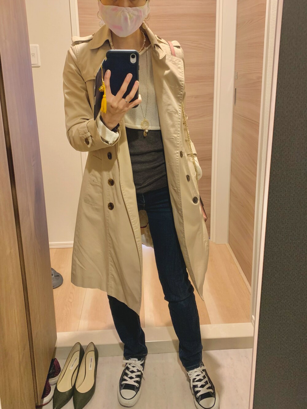 ホワイト系のニット/セーター、ブルー系のデニムパンツ、ピンク系のショルダーバッグを着用したレディースの春コーディネートの2枚目の写真