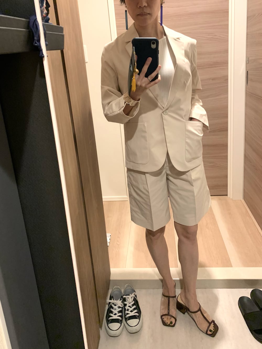 ベージュ系のテーラードジャケット、ベージュ系のローファー、グリーン系のイヤリングを着用したレディースの春コーディネートの4枚目の写真