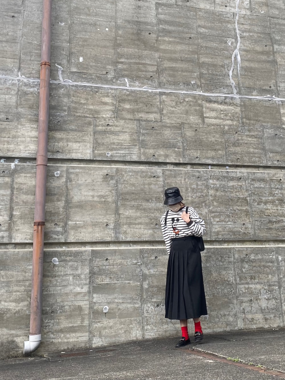 ブラック系のバックパック/リュック、ブラック系のTシャツ/カットソー、ブラック系のローファーを着用したレディースの春コーディネートの3枚目の写真