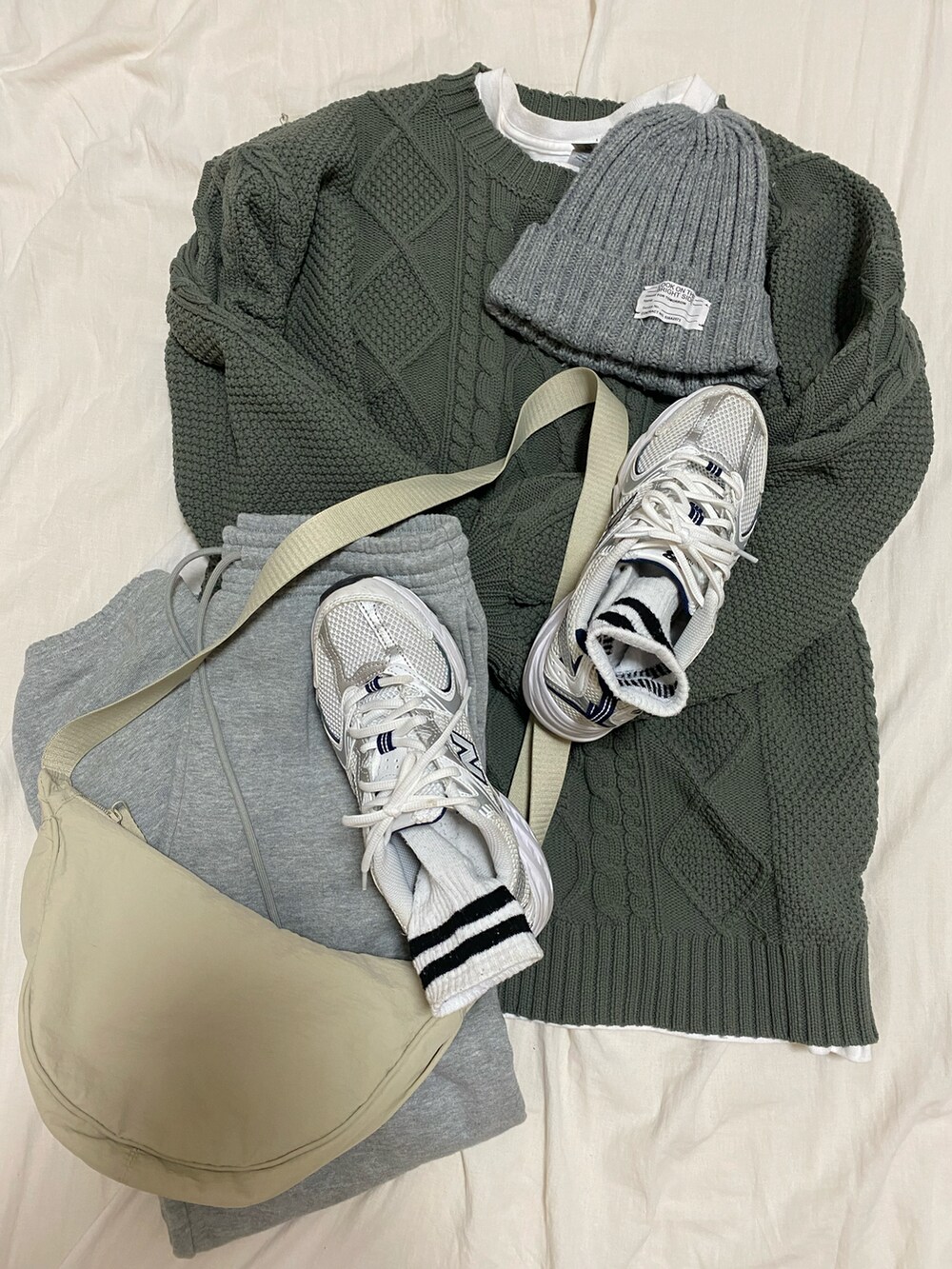 ホワイト系のTシャツ/カットソー、グリーン系のニット/セーター、その他のダウンジャケット/コートを着用したレディースの冬コーディネートの4枚目の写真