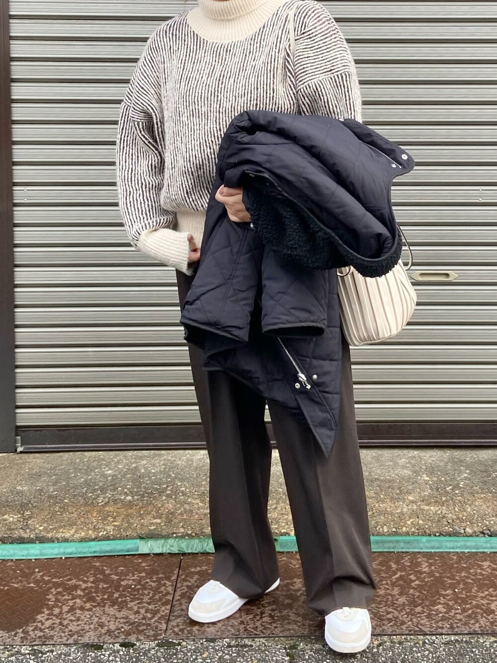 ブラウン系のニット/セーター、ブラック系のノーカラーコート、ブラウン系のスラックスを着用したレディースの冬コーディネートの2枚目の写真